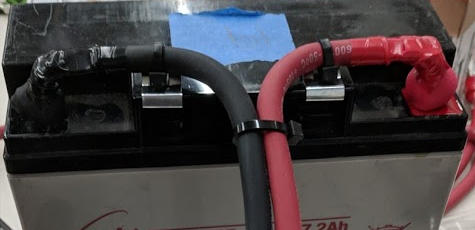 An example showing edge clips with zipties holding leads on a battery.